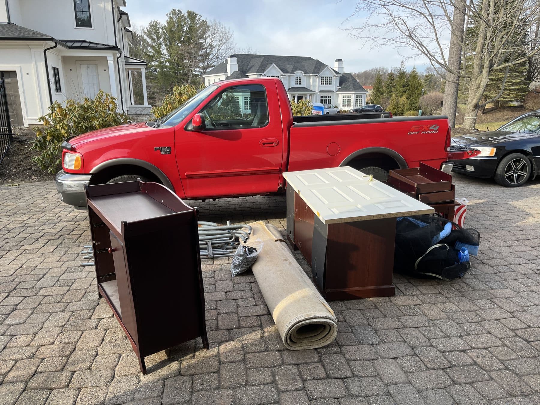 Junk ByeBye pickup truck loaded with furniture and junk on a driveway